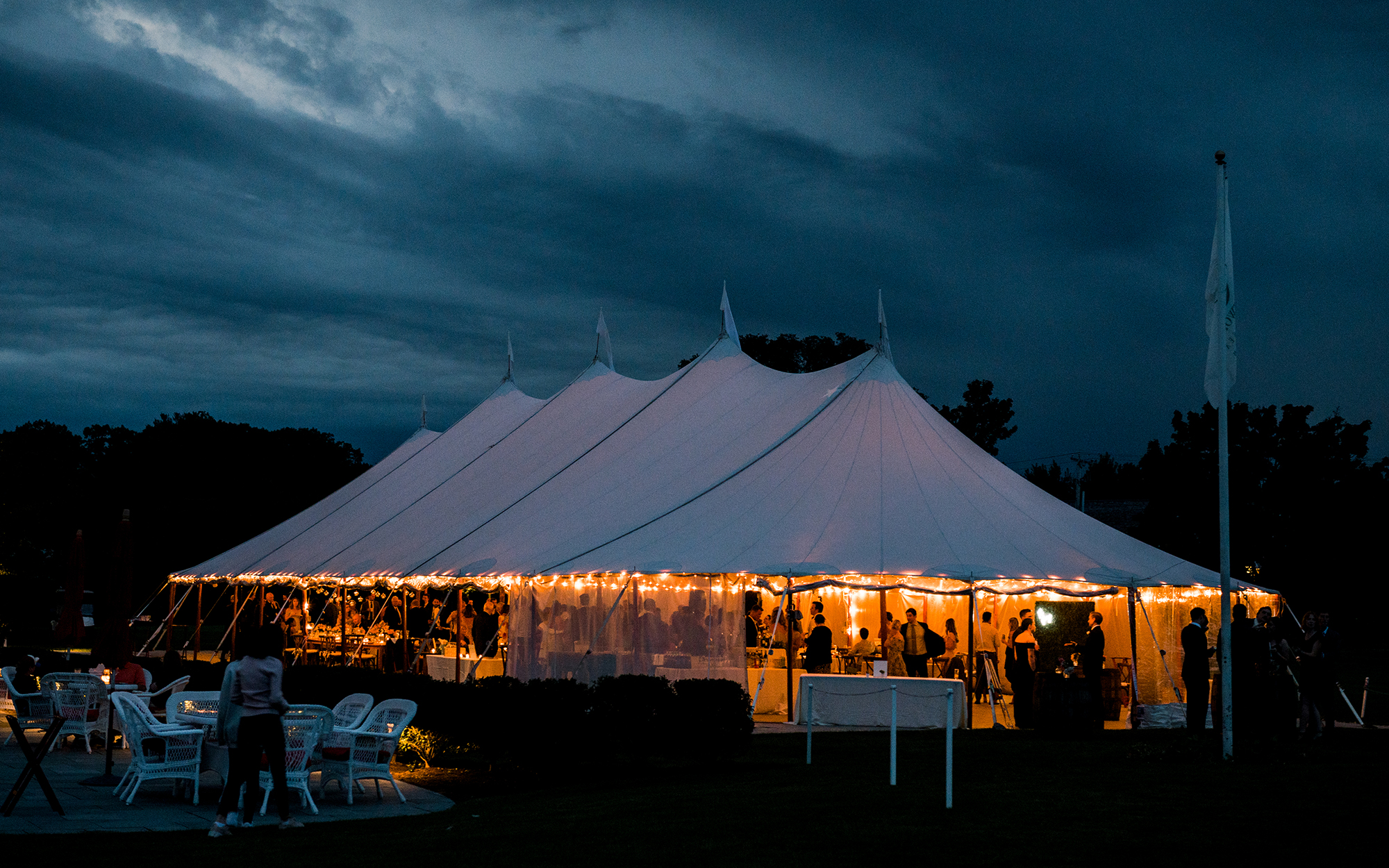 wedding party under tent outdoors at night