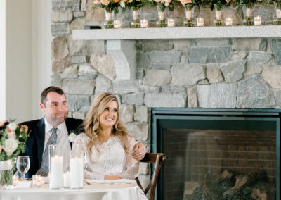 Bride and groom sitting at table by fireplace