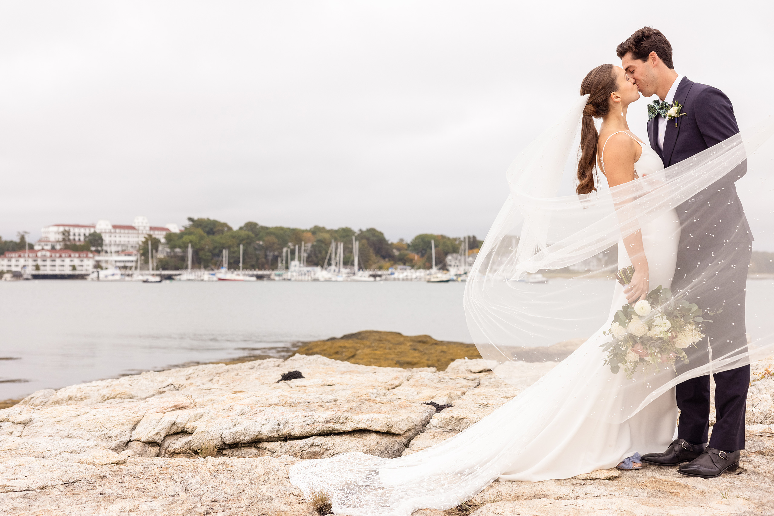 Bride and groom kissing by seaside