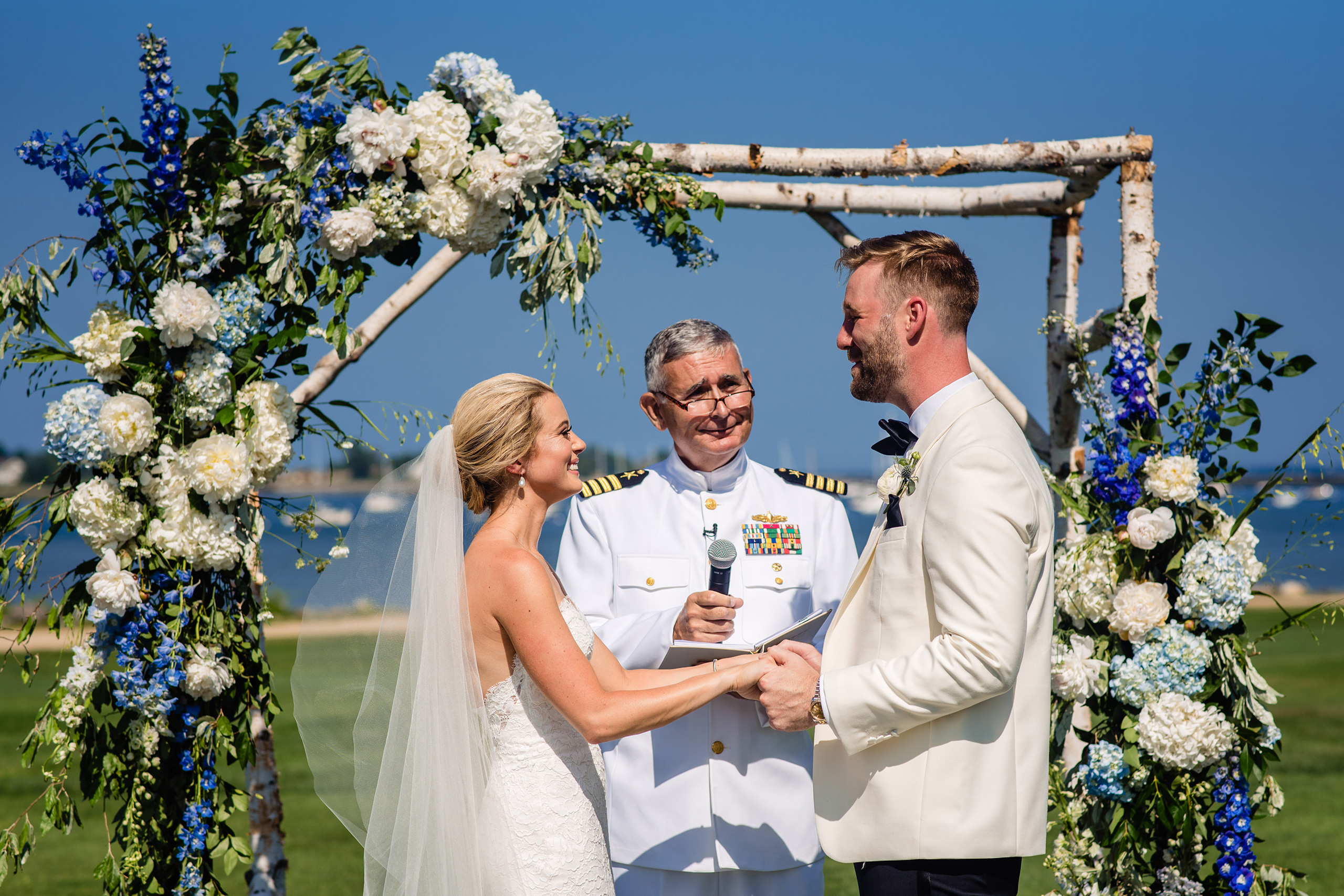 Bride and groom at seaside altar with flower arch