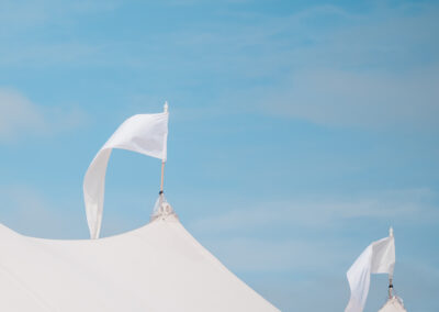 Flags atop outdoor tent