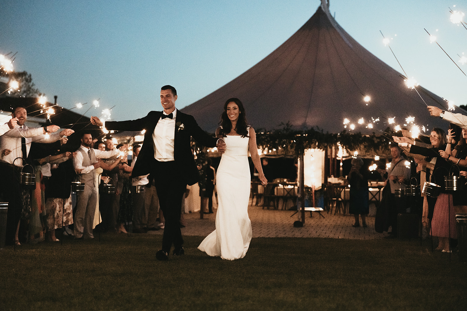 Couple at wedding with a sperry tent behind them