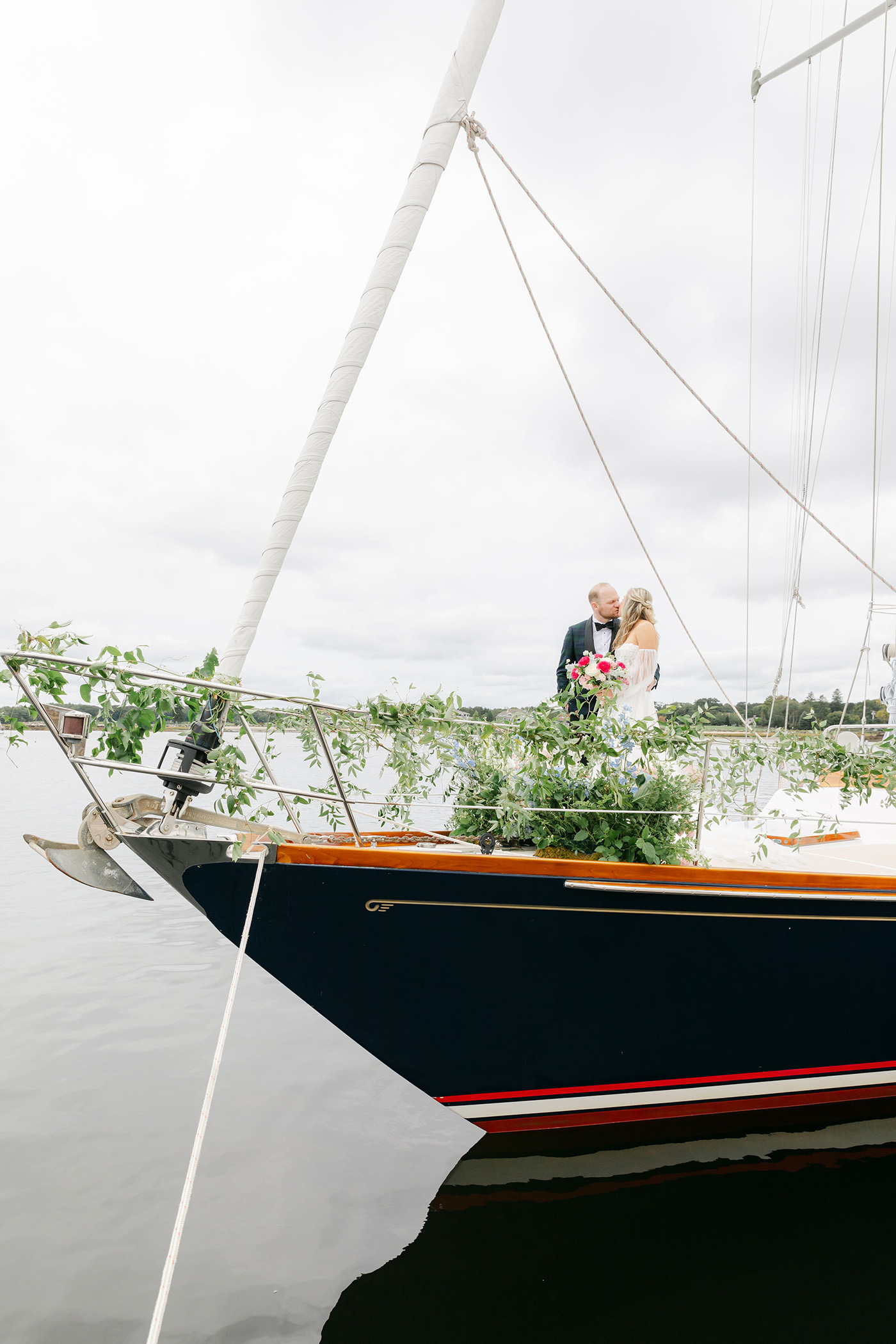 Wedding couple kissing on top of a sailboat on the seaside