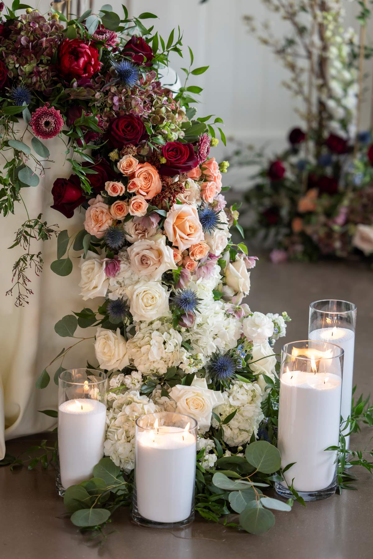 A serene table setting featuring vibrant flowers, flickering candles, and lush greenery, creating a tranquil atmosphere.