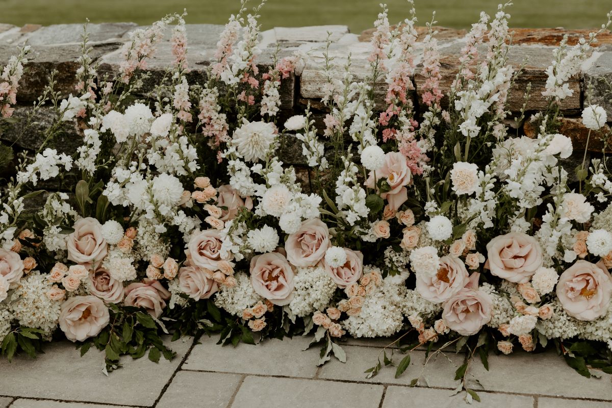 An enchanting wedding ceremony adorned with a wall of flowers, enhancing the ambiance of love and celebration.