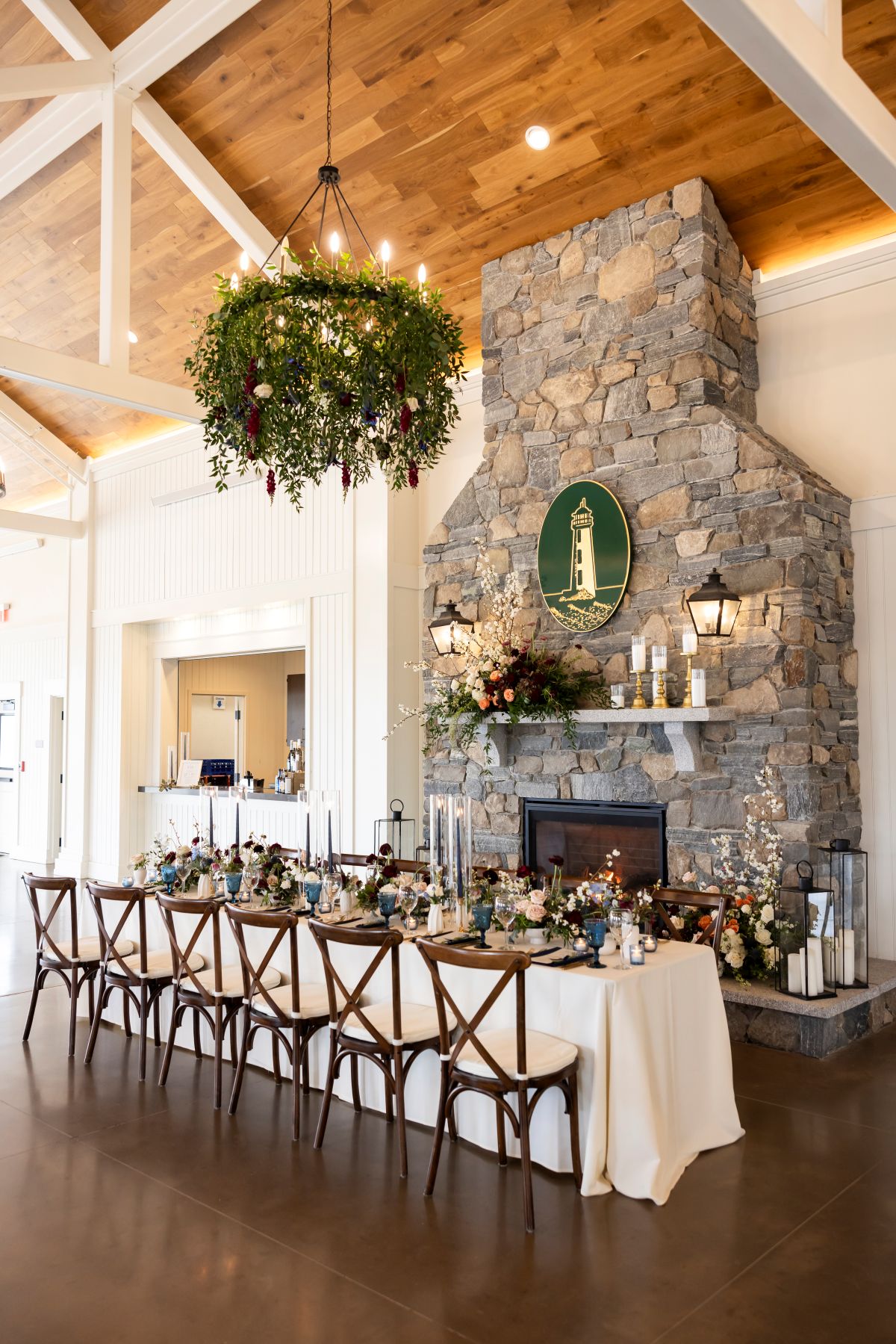 A grand dining room with a stone fireplace, beautifully arranged for a luxurious wedding reception.