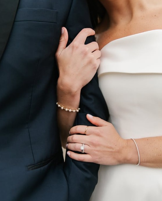 A luxurious wedding couple, the bride in a white dress and the groom in a blue suit, radiating elegance and joy.