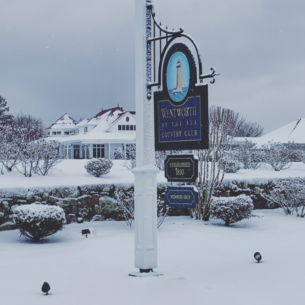 A snow-covered sign on a pole, elegantly marking the entrance to a luxurious wedding venue.