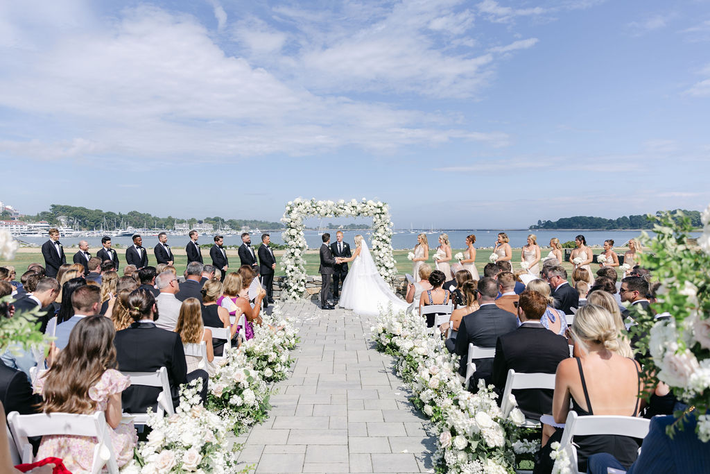 A grand dining room with a stone fireplace, beautifully arranged for a luxurious wedding reception.