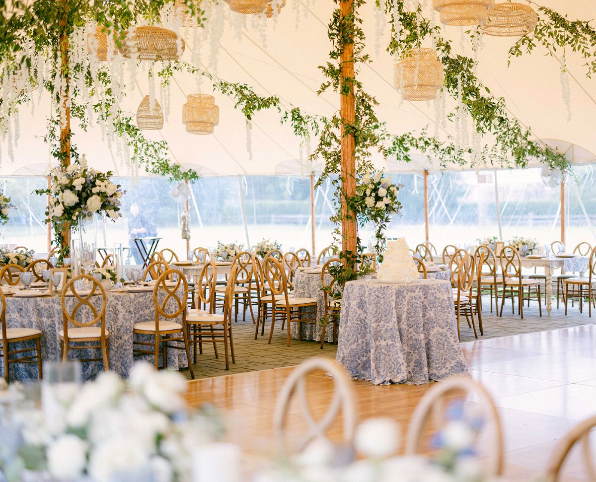 A beautifully decorated wedding reception tent featuring white and blue accents, set against a New Hampshire seaside backdrop.