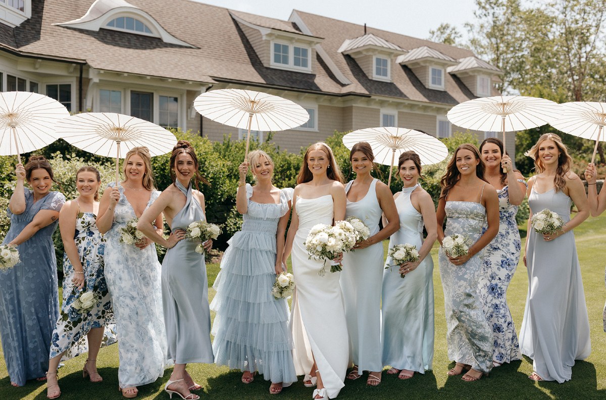 Bridesmaids in elegant blue dresses holding umbrellas at a luxury wedding, creating a stylish and coordinated look.